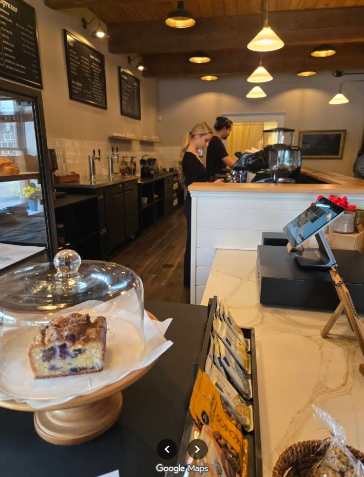 Blueberry crumb cake on a cake stand at the Chadds Ford Coffee House counter